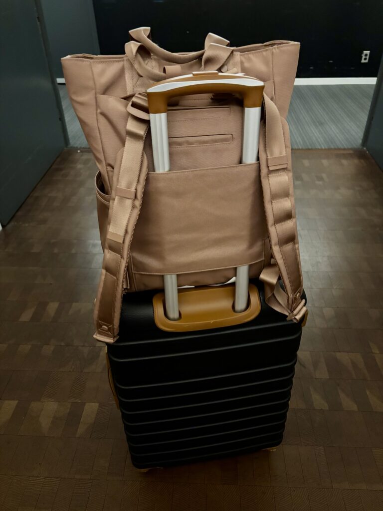 A stylish backpack attached to a wheeled suitcase, creating a convenient product for family travel.