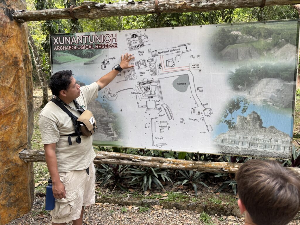 Guide explaining the layout of Xunantunich archaeological site next to a map.